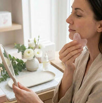 FrostVibe™ rose quartz gua sha in use — natural stone depuffing and facial contouring massage — red light therapy gua sha FrostVibe